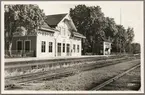 Spårsida av station med vy på stationshus och ställverksbyggnad.