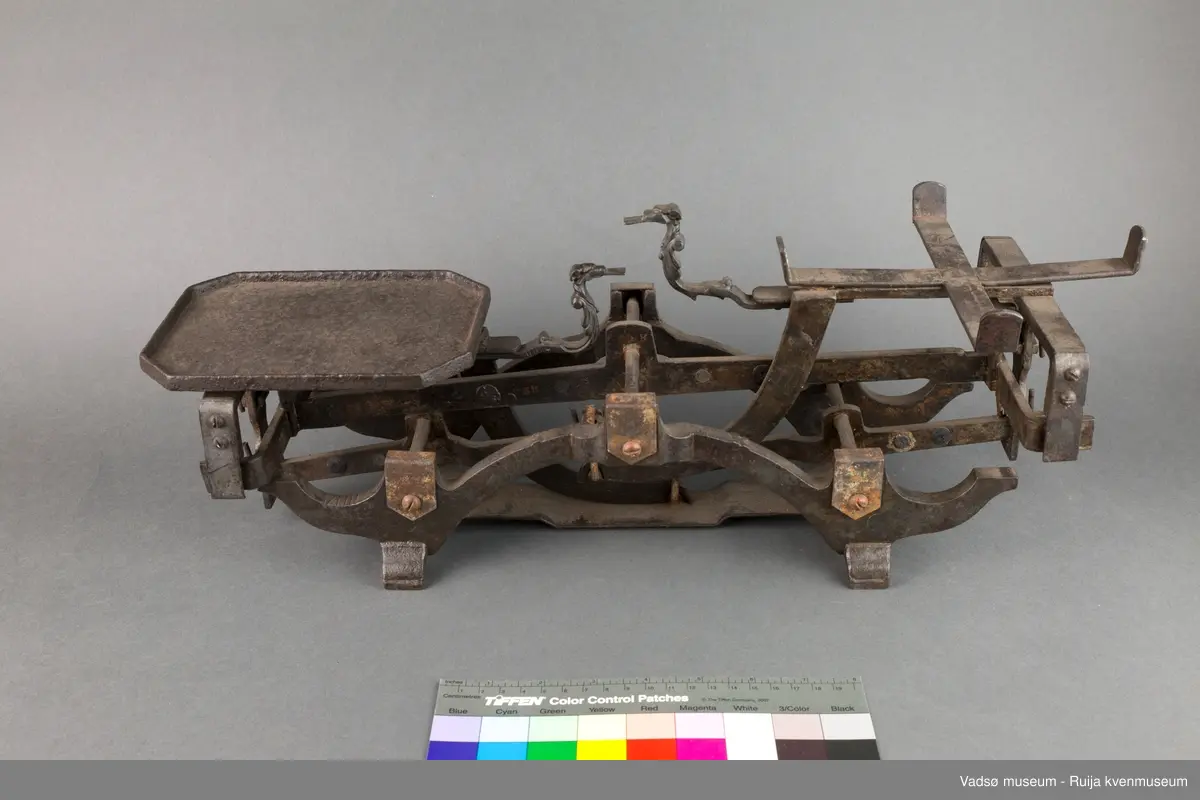 Diskvekt. På ene siden er en rektangulær plate til vektlodd, på andre siden er en løs metallskål for varer. På vektplatene, motstående for hverandre, sitter et ornamentert dyrehode, hver med tunge formet som et flatt jern ut av kjeften. Disse er indikatorer for likevekt. Når "tungene" er i samme høyde og såvidt berører hverandre er vekta i balanse.