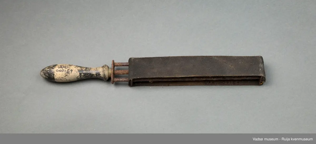 Håndholdt knivsliper. Slipebåndet av lær er spent rundt en enkel ramme av jernspiler. Håndtak i tre. Til finsliping av kniver.