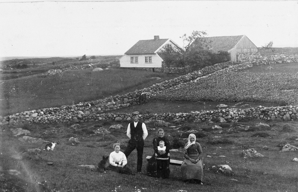 Garden Serigstad sett frå søraust. I framgrunnen f. v. : Gurine Serigstad (1875 - 1934), Jon J. Serigstad (1870 - 1952), Anna Maria f. Lye (1879 - 1961) med Ingebret Serigstad (1899 - 1986) på fanget, Elen Johanna f. Tangen, Norheim (1839 - 1916).