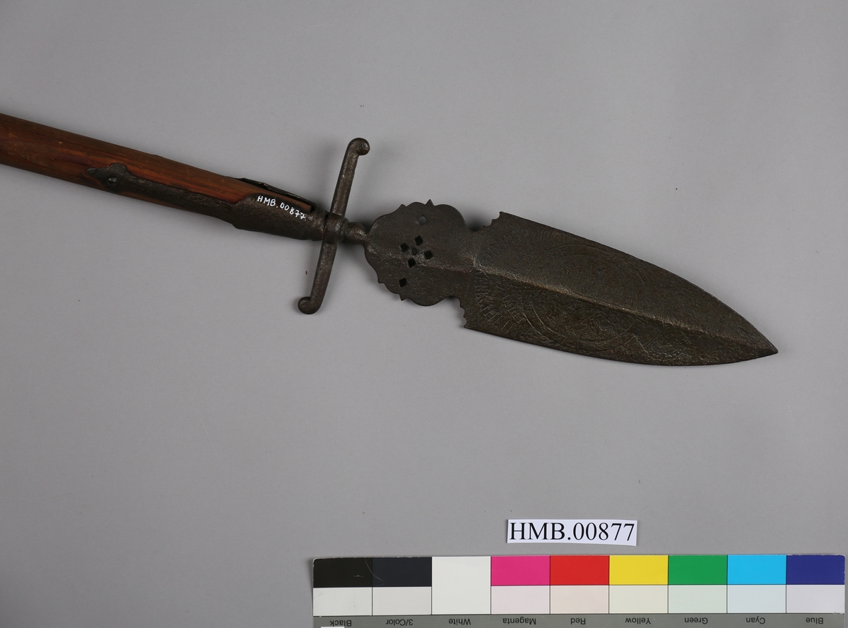 Stikkvåpen med tungeformet klinge og to rette parérstenger med dråpeformet avslutning. To skafteskinner fester klingen til treskaftet.
