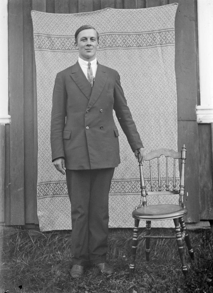 Leirfjord, Ulvangen, Myrvang. Portrett av Lars Guttormsen, f. 21.02.1902 - d. 23.03.1934. Fotografert med sto,l og teppe bak på veggen. Foreldrene til Lars var Lars Guttormsen d.e og Josefine Johannesen.