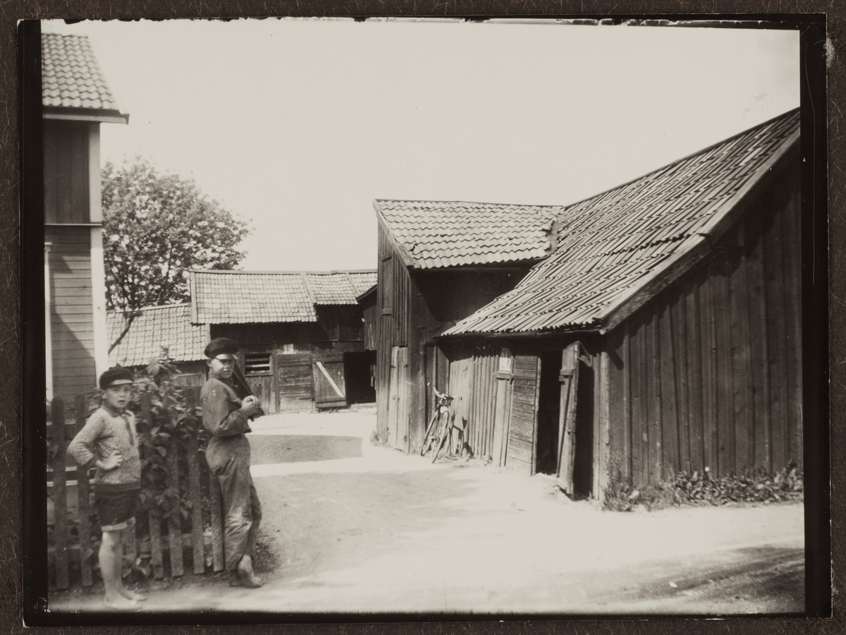 Två pojkar vid ett staket på vägen mellan Uppsala och Almtuna, Fålhagen