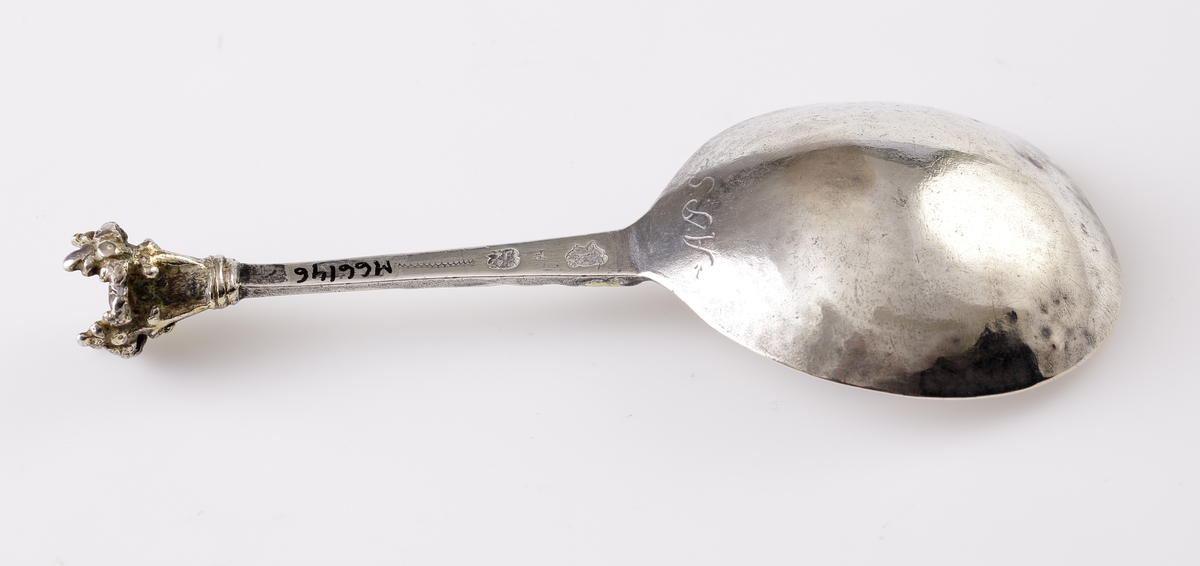 Brännvinssked av silver.
Graverad blomma (delvis förgylld) i skedbladet. Försedd med kronknopp. Stämplar + åldermansranka på baksidan av skaftet (mycket otydliga). Kan ev. vara: Johan Wibom (Wiberg?) (1680-1710), Norrköping.
F = 1698 ?.