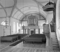 Interiör från nya kyrkan i Skärkind. Kyrkobyggnaden uppfördes under åren 1835-36 efter ritningar av Justus Weinberg. Som byggmästare anlitade församlingen den välrenommerade byggmästaren Abraham Nyström. Interiören blev rymlig med tunnvälvt tak och korsarmar i öster och väster. Ett blixnedslag 1906 tilltvingade ett omfattande restaureringsarbete. Arkitekt Erik Lallerstedt förvandlade den enkla empirekyrkan till en livlig jugenddekorerad helgedom. Predikstolen är dock ursprunglig och utfördes av byggmästarens son, Johan Nyström.