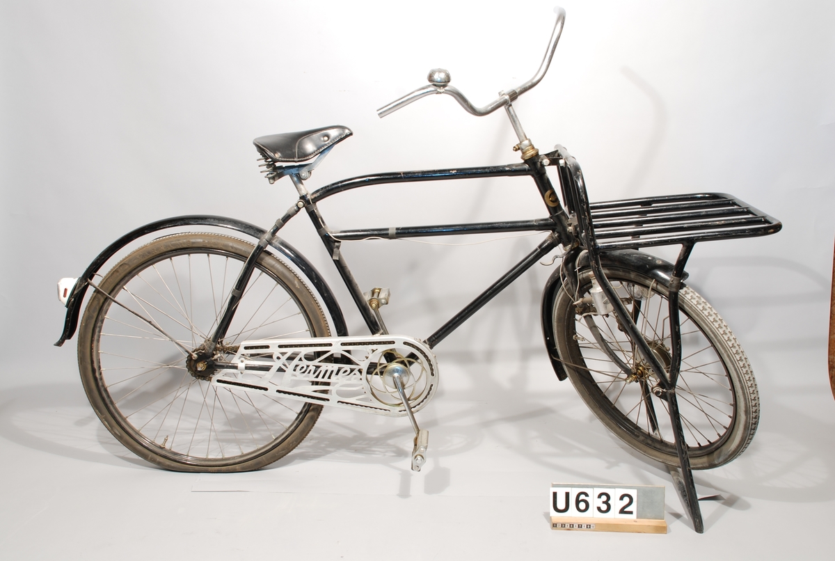 Paketcykel, Crescent. Herrmodell. Text på kedjeskyddet: "Hermes".
Transportcykel, Crescent, svartlackerad med förstärkt övre ram, något svängd. Pakethållare med parkeringsstöd (55X40) fram. Hjuldiameter: fram 24X2 bak 26X2. Belysning: Bosch. Kedjeskydd: Hermes. Fram- och baknav nya, identiska med originalen, ny originalsadel och nya pedaler. Framhjulet har bromstrumma, som ej är inkopplad. I användbart skick.