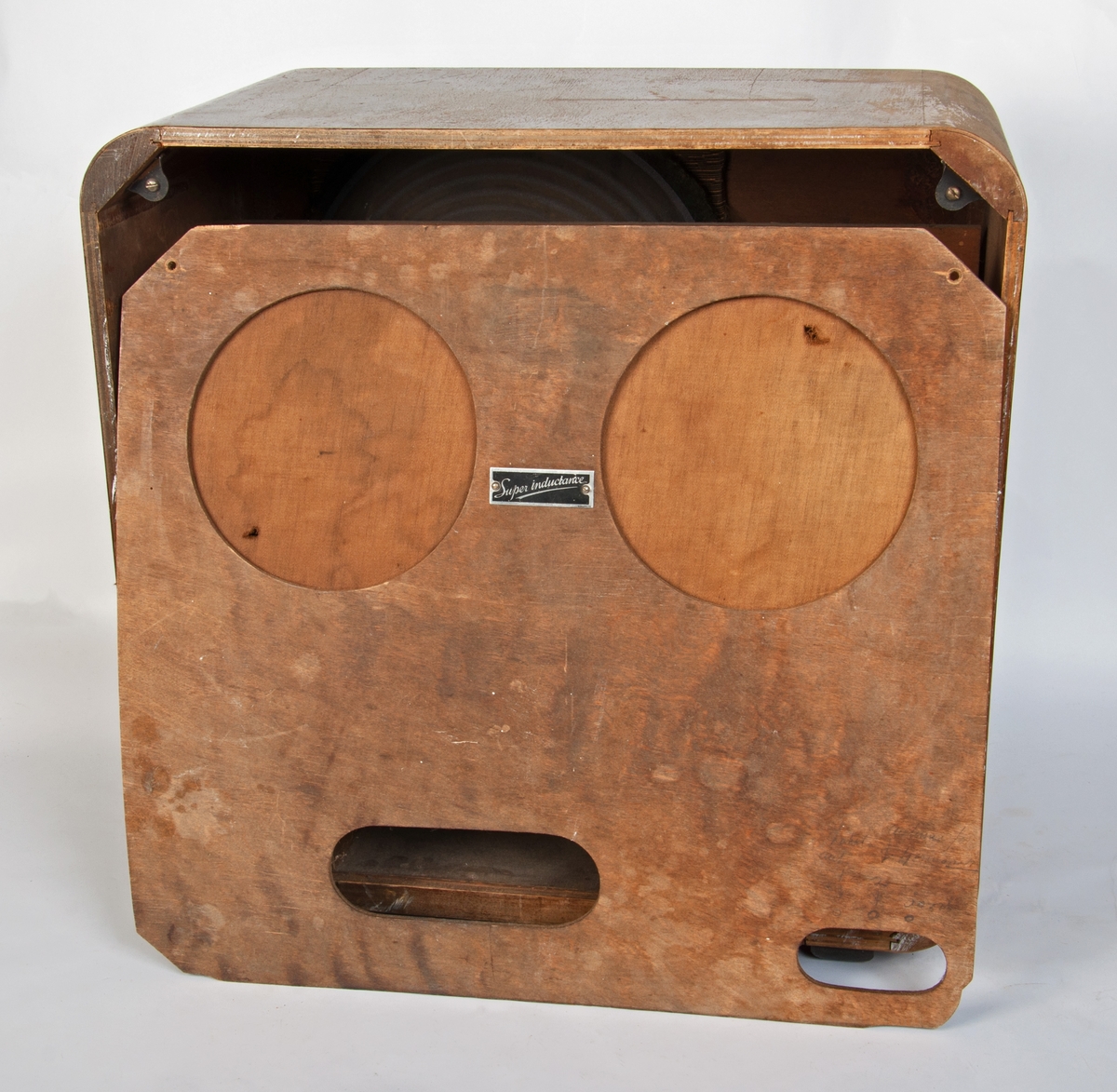 Mørkt tre, lakket, 2 plastknotter framme, stasjonsviser i plast. En treformet høyttaler. Inni: Radio av metall, papp, kobber, ledninger.  
Bakstykket er løst, er en tynn finerplate, to runde hull dekket med stoff, to ovale åpninger nederst. Metallskilt.