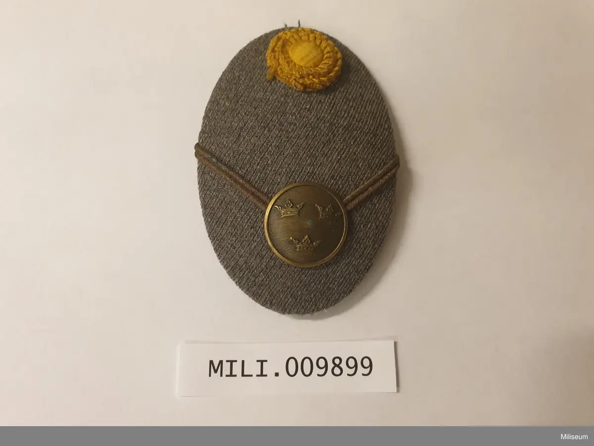 Mössmärke m/1941 för kapten. Med plåtstomme. Försett med den äldre kokarden av tyg.