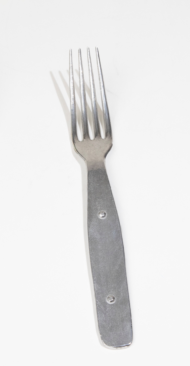 Gaffel av lättmetall. Hör ihop med sked (JM 54960:1), kniv (JM 54960:2) och förpackning (JM 54960:4).