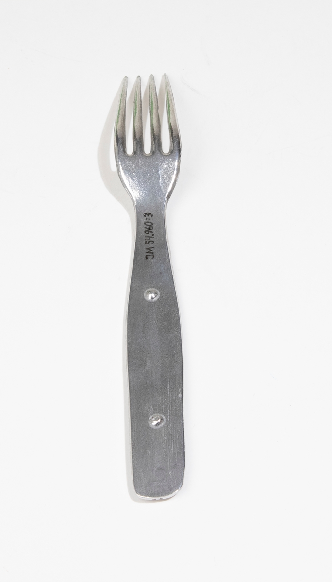 Gaffel av lättmetall. Hör ihop med sked (JM 54960:1), kniv (JM 54960:2) och förpackning (JM 54960:4).