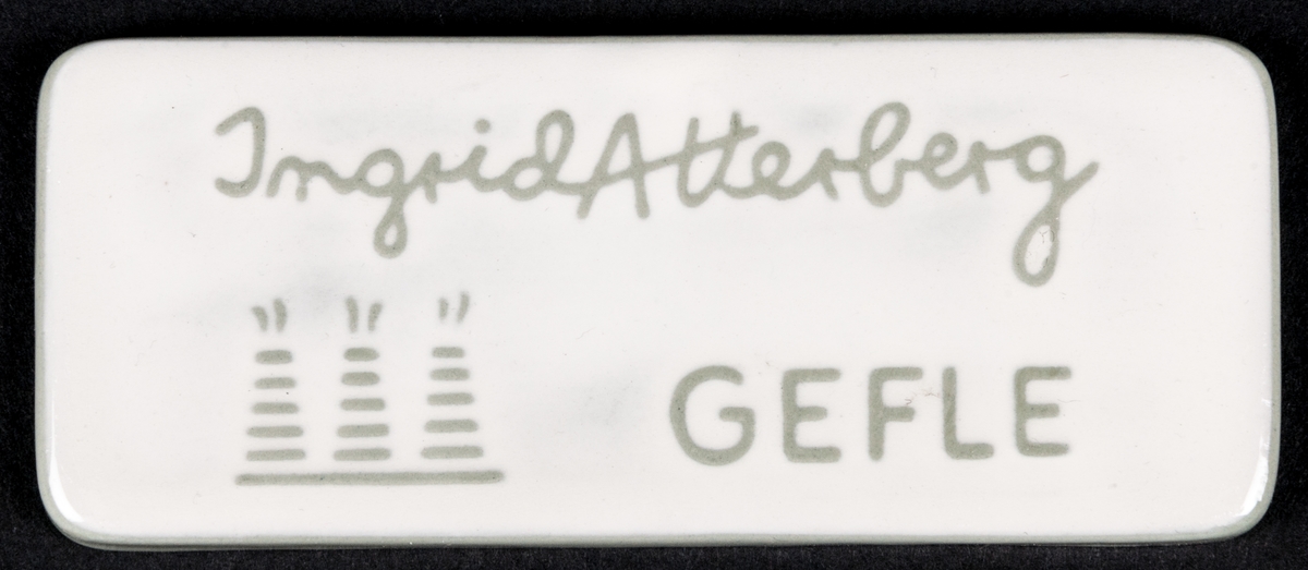 Skylt med stämplad dekor, texten lyder: 
Ingrid Atterberg GEFLE