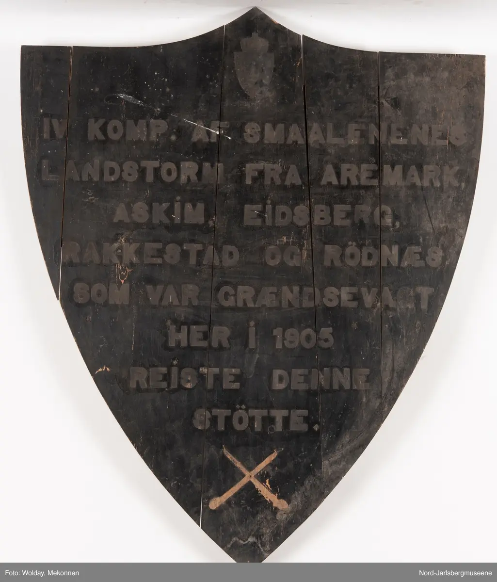 Et skjoldformet form med merker etter/til å feste løse bokstaver etter støping