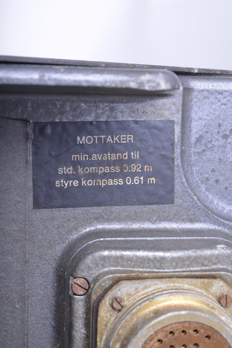 Rektangulært formet av metalI. I toppen to firkantede metallformer noen centimeter hevet fra resten av boksen. I bunnen en rekke med luftehull, samt uttak for tilkobling til strømkabler.