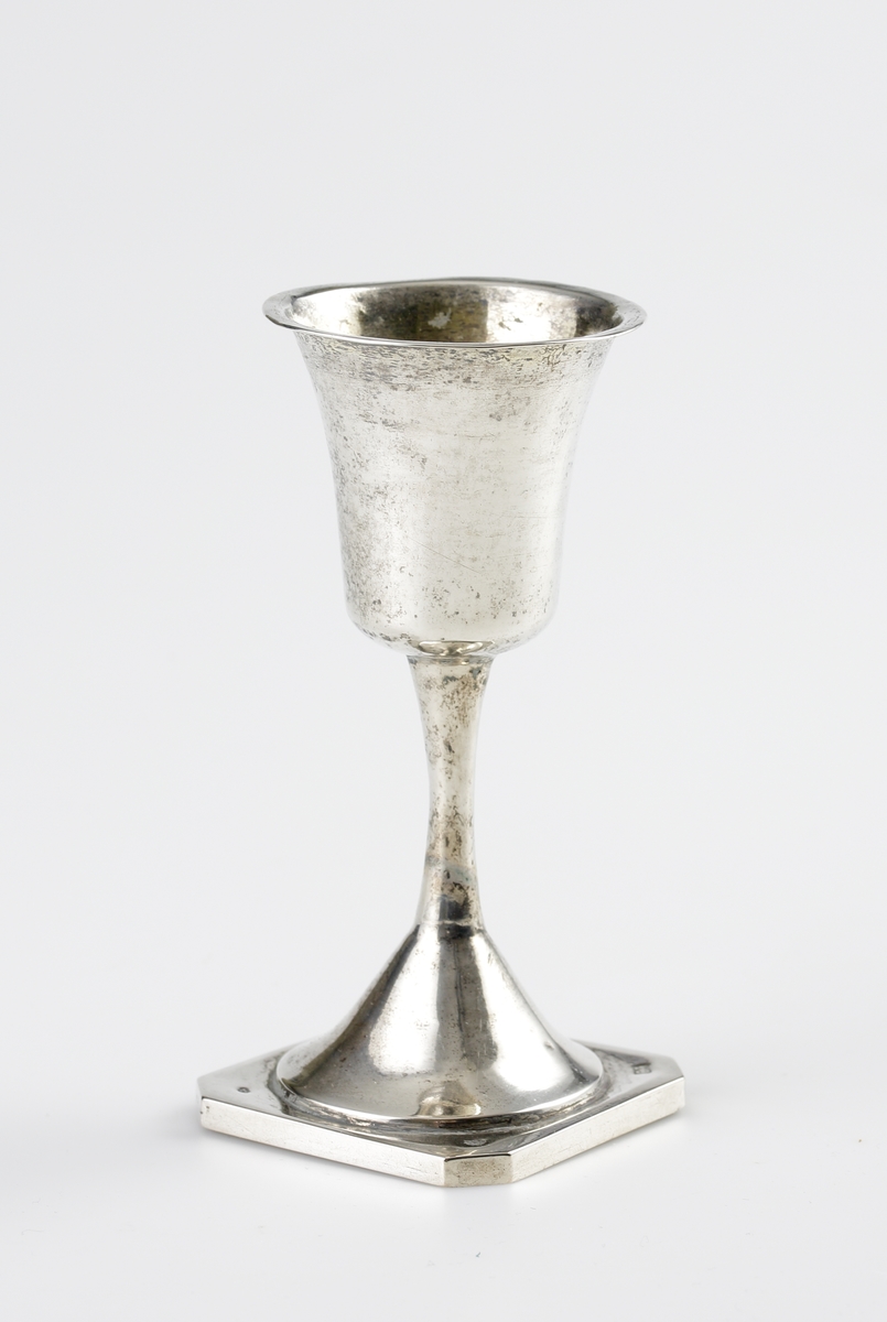 Supkalk i silver.
Enkel modell på fyrkantig fot med avfasade hörn. Stämplar undertill (i alla fyra hörn).