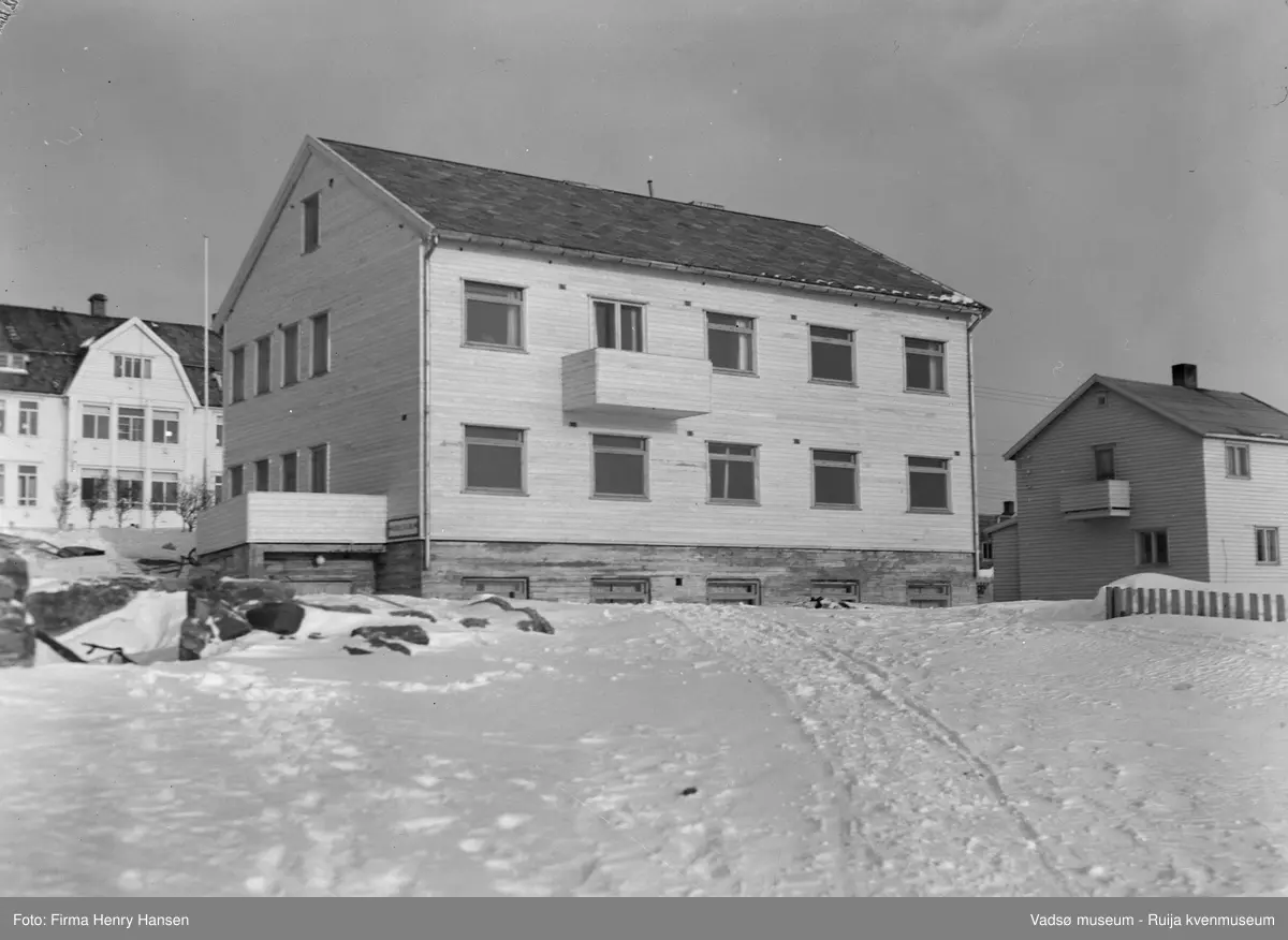 Fødehjemmet i Oscarsgata 20, Vadsø 1952. Bildet er tatt mot nord og vi ser Fødehjemmet midt i bildet. Bak Fødehjemmet Kysthospitalet
I Vadsø bygde sanitetsforeningen et stort fødehjem med legekontor og kontrollstasjon for mor og barn. Fødehjemmet er bygd i 1952, arkitekt Finn Eidvin og hovedentreprenør Alrik Basma.