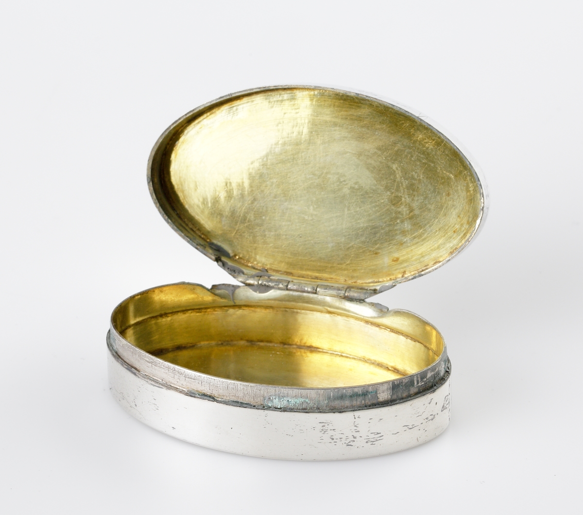 Dosa, silver.
Oval, slät modell. Invändigt förgylld. Ägarinitialer: "J.O.D." på dosans undersida. 
Stämplar (något otydliga) på lockets undersida.