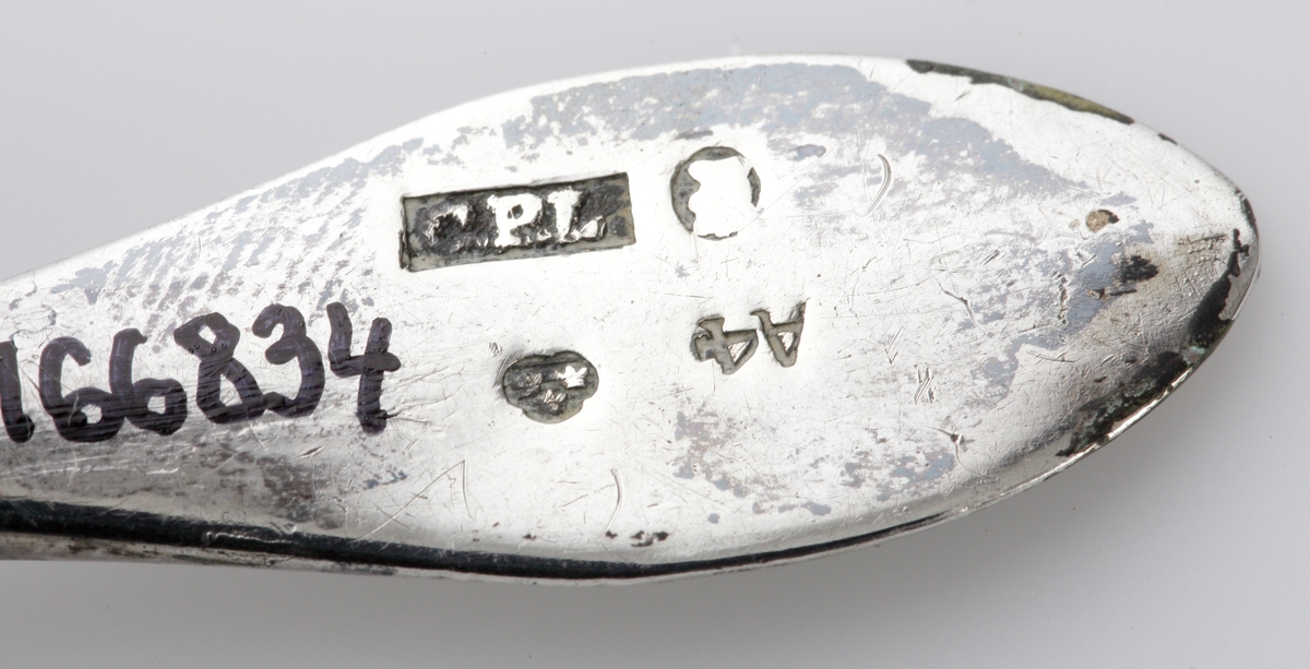 Rakborste av silver, med etui. 
Mindre rakborste med spetsigt, något insvängt skaft i silver. Borst saknas.
Cylindriskt, något avsmalnande etui. 
Stämplar på borstens skaft och på undersidan av etuiet.