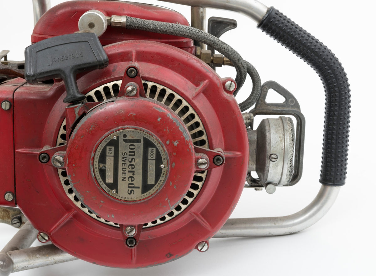 Motorsag av typen Jonsered Raket XD med sverd, påmontert barkstøtte og skovltannkjede. (Barkstøtten brukes fortrinnsvis til kapping av større stokker og ved felling av større trær.)  Saga ser for registrator ut til å være komplett. Det bakre håndtaket er polstret med med svart gummi for å gi brukeren et godt grep.  
Saga er utstyrt med innsprøytiningspumpe i stedet for forgasser. 


Ut fra  medfølgende lapp til saga og andre kilder har saga disse tekniske spesifikasjonene:
Sylindervolum/slagvolum: 85 kubikkcentimeter.
Ytelse: 5,1 hestekrefter ved 6650 omdreininger per minutt. [Også oppgitt til 5,5 HK ved 5500 omdreininger per minutt]
Vekt: 12,2 kg [har også oppgitt en vekt på 12,6 kg, forskjellen kan skyldes veiing med tomme eller fulle olje- og drivstofftanker og ulike sverdtyper]
Den trenger oljeblandet drivstoff i blandingsforholdet 1:20.
Bensintanken rommer 1,10 liter mens oljetanken har et volum på 0,15 liter.
Saga kan utstyrers med sverd fra 15  til 24 tommer.