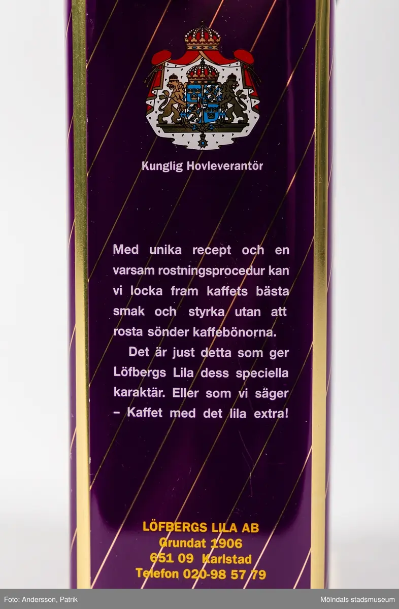Rektangulär plåtburk med patentlock i plast, för förvaring av kaffe. Burken har ett tvärrandigt tryck i lila och guld, samt texten: 
Kaffe (tryckt i vitt inuti en röd ram)
Löfbergs Lila (tryckt i gult) 
”Kaffet med det lila extra!” (tryckt i vitt) 
500g (tryckt i vitt)
På ena kortsidan finns även ett riksvapen med texten Kunglig Hovleverantör tryckt. Locket är i gul plast.