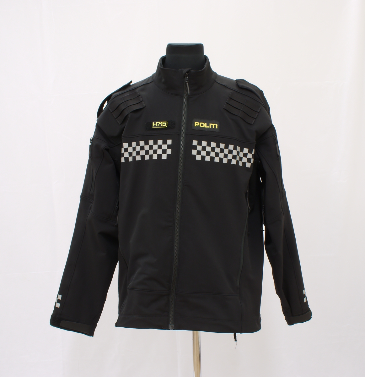 Sort politijakke i tre lag. 

En uniformert softshelljakke utstyrt med bæreløsninger for sambandsutstyr etc. og reflekser. 

En uniformert skalljakke i goretex, som kan bæres alene eller utenpå softshelljakka. Denne er også utstyrt med bæreløsninger og reflekser. Den er vann- og vindtett, og har hette. Begge jakkene har politimerke på begge overarmer. 

(Det tilhørende innerste laget mangler. Dette er en isolasjonsjakke uten politimerking. Jakka skal bæres som et varmende lag under de andre jakkene.)