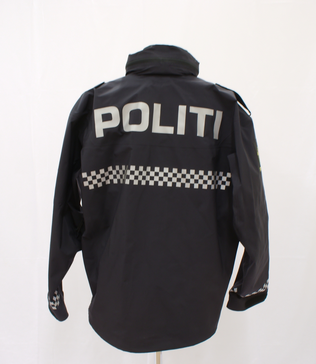 Sort politijakke i tre lag. 

En uniformert softshelljakke utstyrt med bæreløsninger for sambandsutstyr etc. og reflekser. 

En uniformert skalljakke i goretex, som kan bæres alene eller utenpå softshelljakka. Denne er også utstyrt med bæreløsninger og reflekser. Den er vann- og vindtett, og har hette. Begge jakkene har politimerke på begge overarmer. 

(Det tilhørende innerste laget mangler. Dette er en isolasjonsjakke uten politimerking. Jakka skal bæres som et varmende lag under de andre jakkene.)