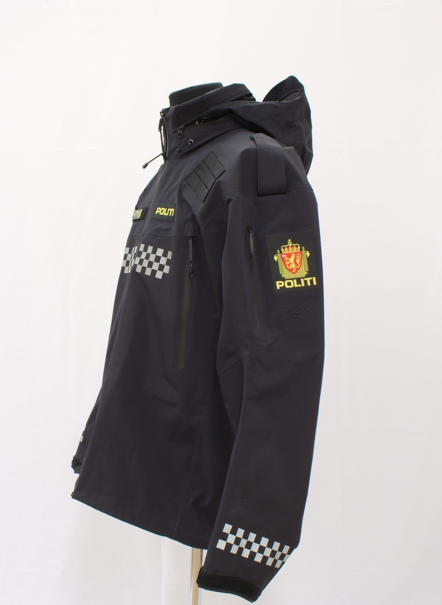 Sort politijakke i tre lag. 

En uniformert softshelljakke utstyrt med bæreløsninger for sambandsutstyr etc. og reflekser. 

En uniformert skalljakke i goretex, som kan bæres alene eller utenpå softshelljakka. Denne er også utstyrt med bæreløsninger og reflekser. Den er vann- og vindtett, og har hette. Begge jakkene har politimerke på begge overarmer. 

(Det tilhørende innerste laget mangler. Dette er en isolasjonsjakke uten politimerking. Jakka skal bæres som et varmende lag under de andre jakkene.)