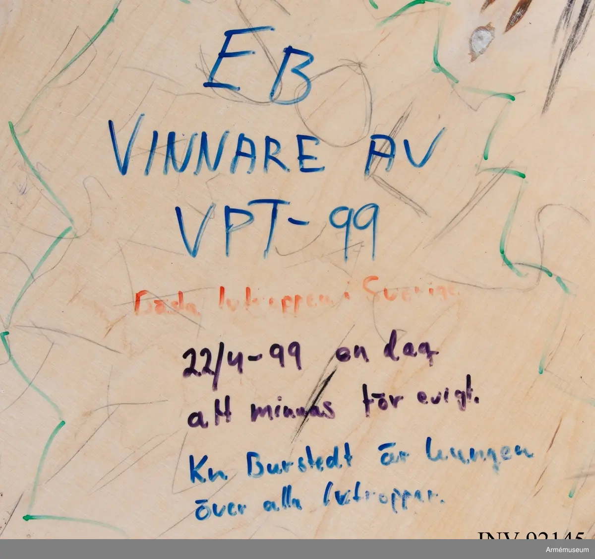 Sängbotten i trä avsedd för våningssäng i metall. Nedklottrad med text och bilder av mestadels sexistisk karaktär. Flera personer har använt ytan för att räkna ned veckorna och dagarna fram till muck.