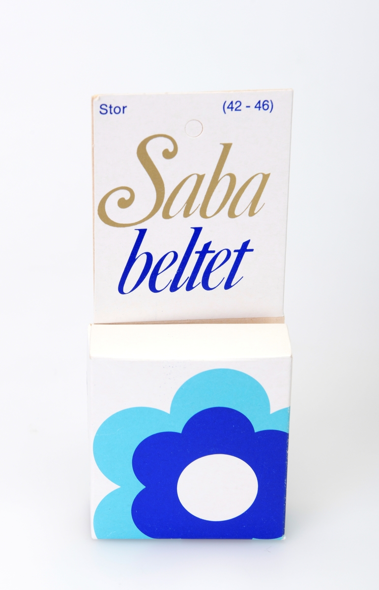 En pakke med Sababelte. På fronten er det påskrift (se påført tekst) i gull, turkis og blått. Under er det en stor stilisert blomst i hvitt, blått og turkis. På baksiden er det informasjon om bruk av Sababeltet med tekst og tegninger. I pakken ligger det et Sababelte som er laget av elastisk kunststoff med hekter av plast.