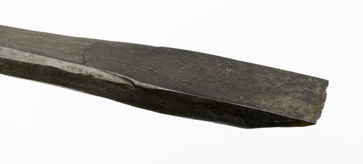 Stemjern med kraftig klinge, muligens så kraftig at den kan karakteriseres som en lokkbeitel, altså et redskap som kunne brukes til å bryte løs flis fra tapphull og andre djupe spalter i et arbeidsstykke av tre. Redskapet er 24,2 centimeter langt. Snaut 17,5 centimeter av dette lengdemålet er en klinge med en noenlunde rett, fasslipt egg i ytterenden. Denne eggen er cirka 2,2 centimeter bred.  Umiddelbart ovenfor eggpartiet har klingen et rektangulært tverrsnitt - 2,2 X 1,1 centimeter. Videre oppover smalner den i bredderetningen, men blir samtidig noe grovere og får et mer kvadratisk tverrsnitt (1,5 X 1,3 centimeter). I overenden av klingen er det en inngående avsats med en tange i forlengelsen av klingens lengdeakse. Den nedre delen av tangen har et tverrsnitt på 1,4 X 1,2 centimeter. Derfra mot den ytre enden smalner den en jevnt. Tangen skulle føres inn i en åpning sentralt i den nedre enden av det treskaftet dette stemjernet antakelig har hatt. Den har hakk i ytterkantene som skulle hindre at den løsnet. Da redskapet ble avlevert til Norsk Skogbruksmuseum manglet skaftet, og i mangle av skaft ser det ut til at snekkeren har banket på enden av tangen med en hammer. Ytterenden av tangen er i hvert fall stuket. Denne redskapsdelen er 5,7 centimeter lang.

Dette stemjernet var antakelig rustent da det ble overlatt til Norsk Skogbruksmuseum. Museets personale har sørget for elektrolysebehandling og påfølgende impregnering med korrosjonsherdende voks.