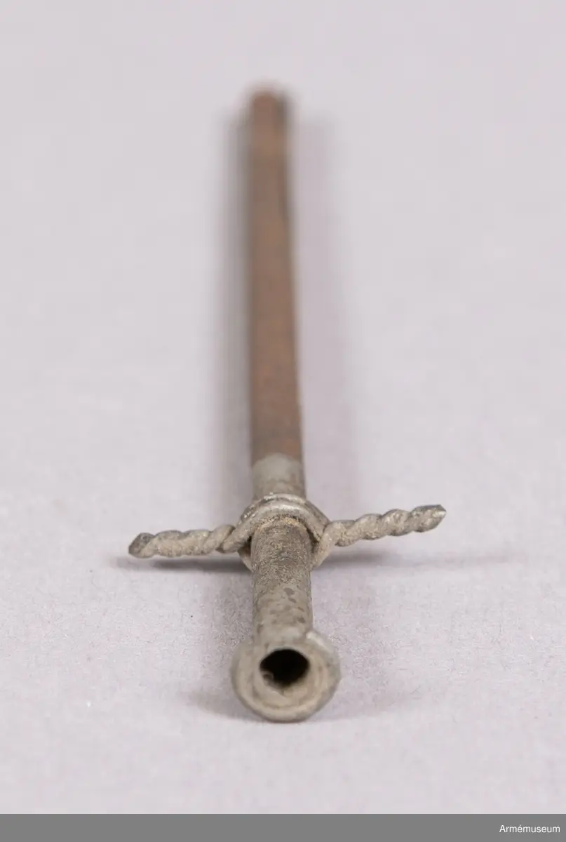 Grupp F II.
Antändningsrör. Callerströms invention 1829-30. Tändningen skedde genom att medelst en dragkrok avbryta rörets övre del, varvid där i ett glasrör förvarad svavelsyra utföll å klorsyrat kali, då explosion inträffade. Antogs vid fältartilleriet 1830.