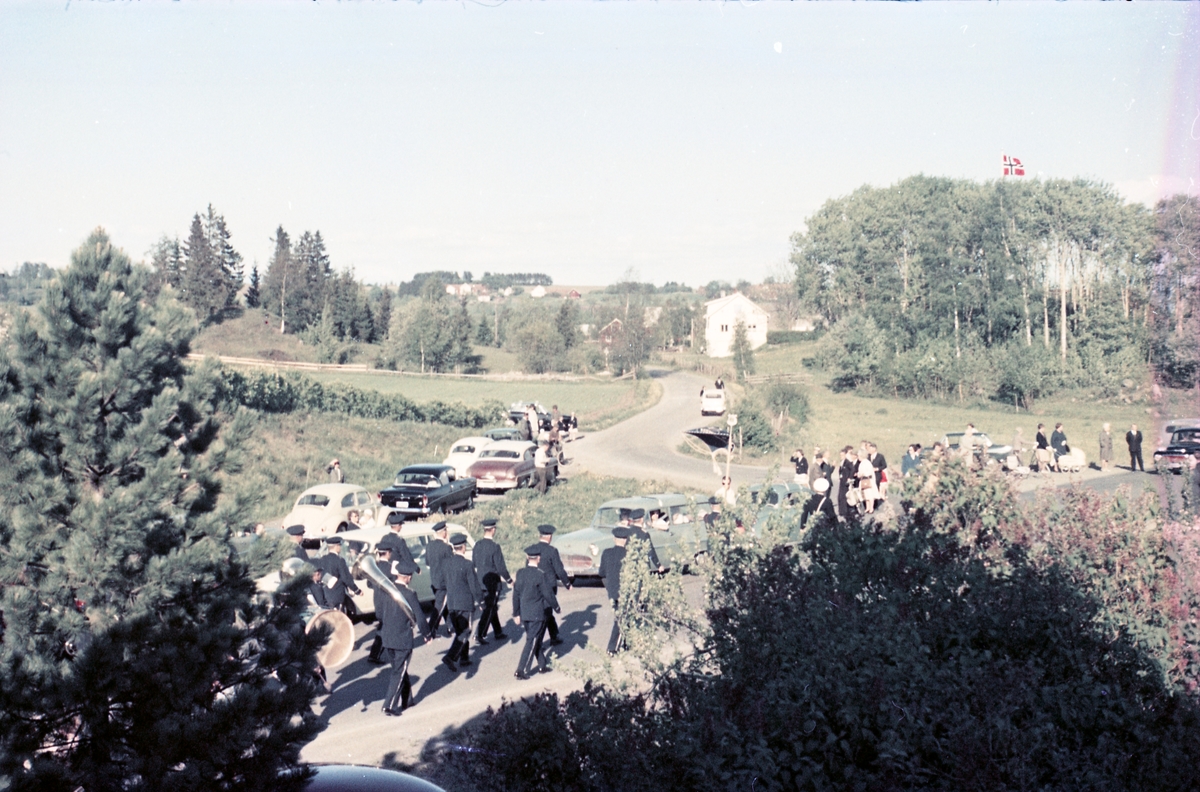 Serie på 16 bilder trolig fra Sangens og Musikkens Dag i Østre Toten, muligens 1961. Bildene er tatt i retning Brunsberg fra fotografens eiendom Odberg på Kraby, der forskjellige korps og kor deffilerer forbi.