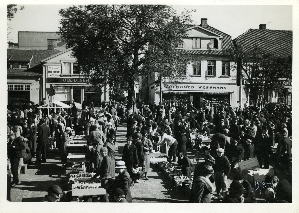 Fredrikstad,
Vestsiden,
Torvhandel
Blomstertorvet ,
Storgaten 10 (bygning til venstre) Forretn.  - Fred Hansen, fotograf,  - Ole Olsen, kjøtthandel
Storgaten 8 (nabobygning t.h. for 10) Forretn.  - Gullsmed Wessmann
Storgaten 6 (nabobygning deretter)  - Taarviggården, Forretn. - Anton Olsen bokhandel