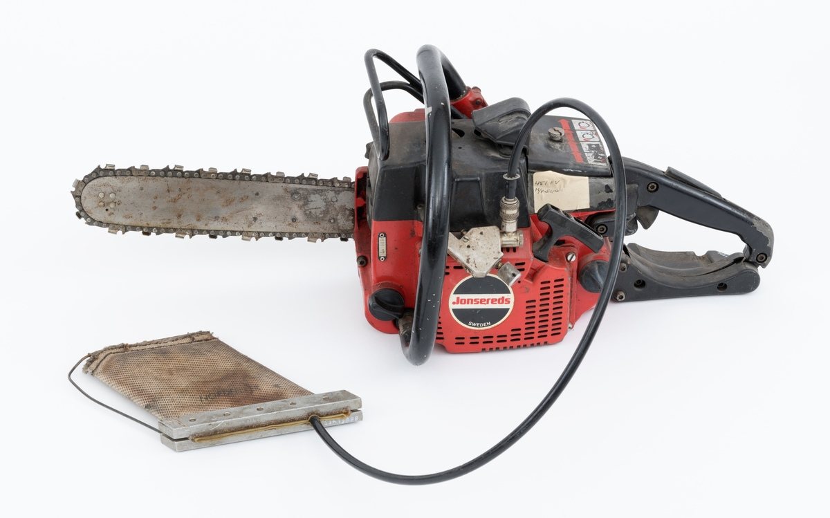 Motorsag av typen Jonsered 451EV med fellepute. Saga har påmontert sverd og sagkjede. Den ser for registrator ut til å være tilnærmet komplett og er videre blant annet utstyrt med elektronisk tenning,  avvibrerte håndtak, varme i håndtakene, vernebøyle og kjedebrems. 

Fellepute/presspute: Tilleggsutstyr påkoblet saga til hjelp under felling. Pressputa/felleputa kunne erstatte bruken av brytejern/fellespett. Utstyret består av en slange, hurtigkobling og pute. Puta har en tilnærmet rektangulær form, cirka 20 x 13 cm. Puta er laget av fiberarmert gummi. Selve puta er festet til en ramme bestående av to metallskinner i ene enden og en metalltråd som omslutter på tre sider. I nedre kant er puta festet til metalltråden med stålklemmer. Til puta er det koblet en svart slange med hurtigkobling. Disse enhetene har en lengde på cirka cirka 1 meter.  Slangen med hurtigkobling festes til en regulator på saga. Denne regulatoren er koblet til sagas motor inn ved starthuset. Det overføres "gass" fra sagas motor, sylinder, til puta som blåses opp som en ballong. Puta stikkes inn i felleskåret, slangen kobles på saga, og brukeren trykker på knappen slik at den fylles med "gass" og dermed hjelper treet i fallretningen.  Ut fra omtale i Jonsereds brosjyre skal puta ha en løftekraft på 4 tonn.  (Se vedlagte filer under fanen referanser.)


Det gjengis her noen tekniske spesifikasjoner fra salgsbrosjyra for Jonsered 451EV:  
(Se også vedlagt fil under fanen referanser som viser en allmenn beskrivelse av sagas spesifikasjoner. )
Sylindervolum/slagvolum: 44,3 kubikkcentimeter.
Kjedehastighet: cirka 20 meter per sekund.
Vekt: cirka 6,1 kg med sverd og kjede, også oppgitt til 7 kg (trolig vekt med fulle tanker)