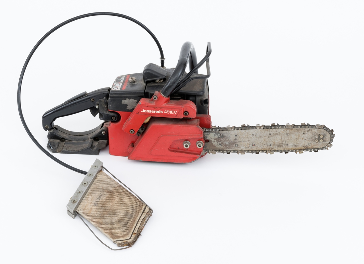 Motorsag av typen Jonsered 451EV med fellepute. Saga har påmontert sverd og sagkjede. Den ser for registrator ut til å være tilnærmet komplett og er videre blant annet utstyrt med elektronisk tenning,  avvibrerte håndtak, varme i håndtakene, vernebøyle og kjedebrems. 

Fellepute/presspute: Tilleggsutstyr påkoblet saga til hjelp under felling. Pressputa/felleputa kunne erstatte bruken av brytejern/fellespett. Utstyret består av en slange, hurtigkobling og pute. Puta har en tilnærmet rektangulær form, cirka 20 x 13 cm. Puta er laget av fiberarmert gummi. Selve puta er festet til en ramme bestående av to metallskinner i ene enden og en metalltråd som omslutter på tre sider. I nedre kant er puta festet til metalltråden med stålklemmer. Til puta er det koblet en svart slange med hurtigkobling. Disse enhetene har en lengde på cirka cirka 1 meter.  Slangen med hurtigkobling festes til en regulator på saga. Denne regulatoren er koblet til sagas motor inn ved starthuset. Det overføres "gass" fra sagas motor, sylinder, til puta som blåses opp som en ballong. Puta stikkes inn i felleskåret, slangen kobles på saga, og brukeren trykker på knappen slik at den fylles med "gass" og dermed hjelper treet i fallretningen.  Ut fra omtale i Jonsereds brosjyre skal puta ha en løftekraft på 4 tonn.  (Se vedlagte filer under fanen referanser.)


Det gjengis her noen tekniske spesifikasjoner fra salgsbrosjyra for Jonsered 451EV:  
(Se også vedlagt fil under fanen referanser som viser en allmenn beskrivelse av sagas spesifikasjoner. )
Sylindervolum/slagvolum: 44,3 kubikkcentimeter.
Kjedehastighet: cirka 20 meter per sekund.
Vekt: cirka 6,1 kg med sverd og kjede, også oppgitt til 7 kg (trolig vekt med fulle tanker)