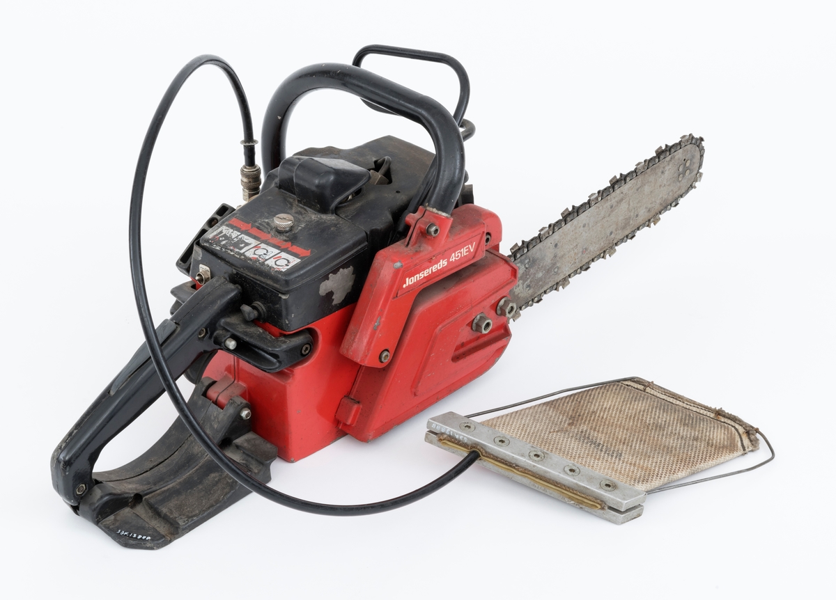 Motorsag av typen Jonsered 451EV med fellepute. Saga har påmontert sverd og sagkjede. Den ser for registrator ut til å være tilnærmet komplett og er videre blant annet utstyrt med elektronisk tenning,  avvibrerte håndtak, varme i håndtakene, vernebøyle og kjedebrems. 

Fellepute/presspute: Tilleggsutstyr påkoblet saga til hjelp under felling. Pressputa/felleputa kunne erstatte bruken av brytejern/fellespett. Utstyret består av en slange, hurtigkobling og pute. Puta har en tilnærmet rektangulær form, cirka 20 x 13 cm. Puta er laget av fiberarmert gummi. Selve puta er festet til en ramme bestående av to metallskinner i ene enden og en metalltråd som omslutter på tre sider. I nedre kant er puta festet til metalltråden med stålklemmer. Til puta er det koblet en svart slange med hurtigkobling. Disse enhetene har en lengde på cirka cirka 1 meter.  Slangen med hurtigkobling festes til en regulator på saga. Denne regulatoren er koblet til sagas motor inn ved starthuset. Det overføres "gass" fra sagas motor, sylinder, til puta som blåses opp som en ballong. Puta stikkes inn i felleskåret, slangen kobles på saga, og brukeren trykker på knappen slik at den fylles med "gass" og dermed hjelper treet i fallretningen.  Ut fra omtale i Jonsereds brosjyre skal puta ha en løftekraft på 4 tonn.  (Se vedlagte filer under fanen referanser.)


Det gjengis her noen tekniske spesifikasjoner fra salgsbrosjyra for Jonsered 451EV:  
(Se også vedlagt fil under fanen referanser som viser en allmenn beskrivelse av sagas spesifikasjoner. )
Sylindervolum/slagvolum: 44,3 kubikkcentimeter.
Kjedehastighet: cirka 20 meter per sekund.
Vekt: cirka 6,1 kg med sverd og kjede, også oppgitt til 7 kg (trolig vekt med fulle tanker)