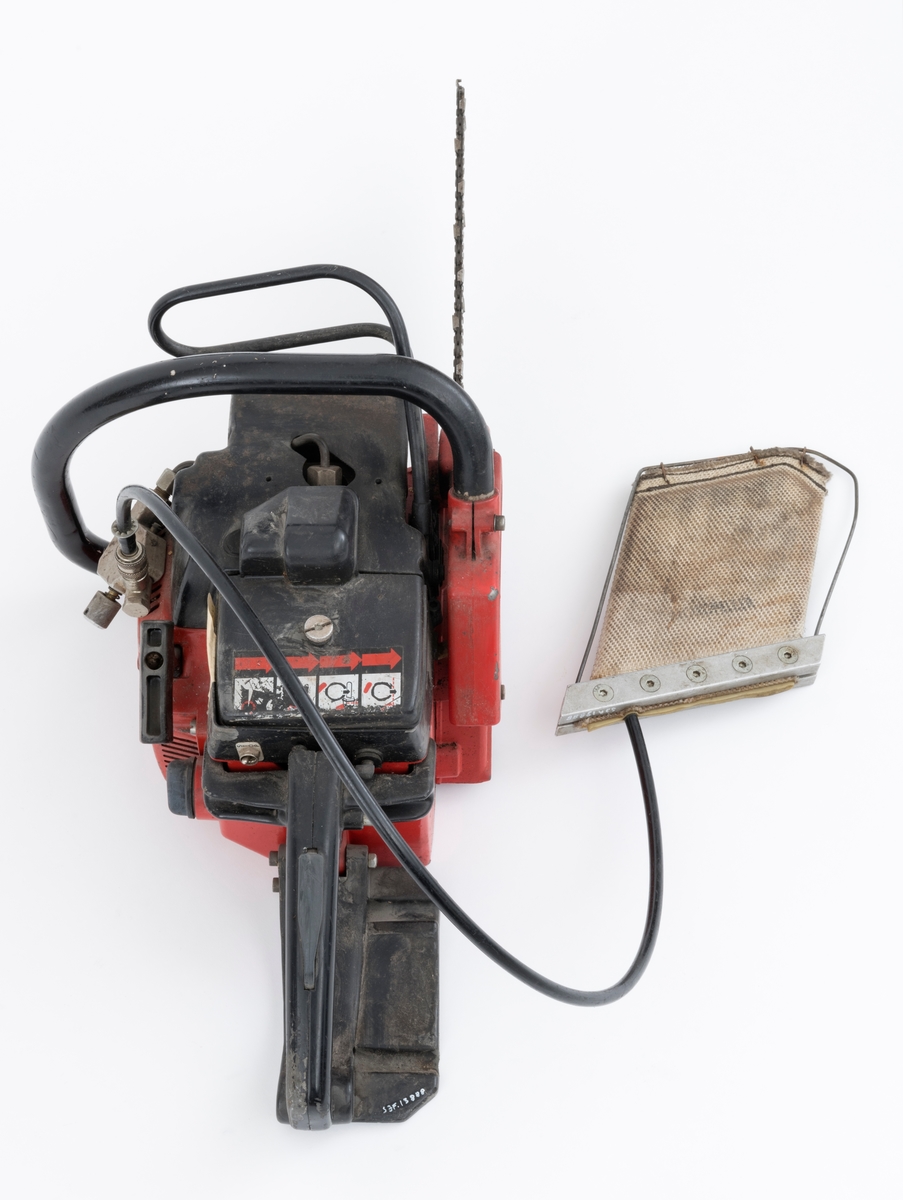 Motorsag av typen Jonsered 451EV med fellepute. Saga har påmontert sverd og sagkjede. Den ser for registrator ut til å være tilnærmet komplett og er videre blant annet utstyrt med elektronisk tenning,  avvibrerte håndtak, varme i håndtakene, vernebøyle og kjedebrems. 

Fellepute/presspute: Tilleggsutstyr påkoblet saga til hjelp under felling. Pressputa/felleputa kunne erstatte bruken av brytejern/fellespett. Utstyret består av en slange, hurtigkobling og pute. Puta har en tilnærmet rektangulær form, cirka 20 x 13 cm. Puta er laget av fiberarmert gummi. Selve puta er festet til en ramme bestående av to metallskinner i ene enden og en metalltråd som omslutter på tre sider. I nedre kant er puta festet til metalltråden med stålklemmer. Til puta er det koblet en svart slange med hurtigkobling. Disse enhetene har en lengde på cirka cirka 1 meter.  Slangen med hurtigkobling festes til en regulator på saga. Denne regulatoren er koblet til sagas motor inn ved starthuset. Det overføres "gass" fra sagas motor, sylinder, til puta som blåses opp som en ballong. Puta stikkes inn i felleskåret, slangen kobles på saga, og brukeren trykker på knappen slik at den fylles med "gass" og dermed hjelper treet i fallretningen.  Ut fra omtale i Jonsereds brosjyre skal puta ha en løftekraft på 4 tonn.  (Se vedlagte filer under fanen referanser.)


Det gjengis her noen tekniske spesifikasjoner fra salgsbrosjyra for Jonsered 451EV:  
(Se også vedlagt fil under fanen referanser som viser en allmenn beskrivelse av sagas spesifikasjoner. )
Sylindervolum/slagvolum: 44,3 kubikkcentimeter.
Kjedehastighet: cirka 20 meter per sekund.
Vekt: cirka 6,1 kg med sverd og kjede, også oppgitt til 7 kg (trolig vekt med fulle tanker)