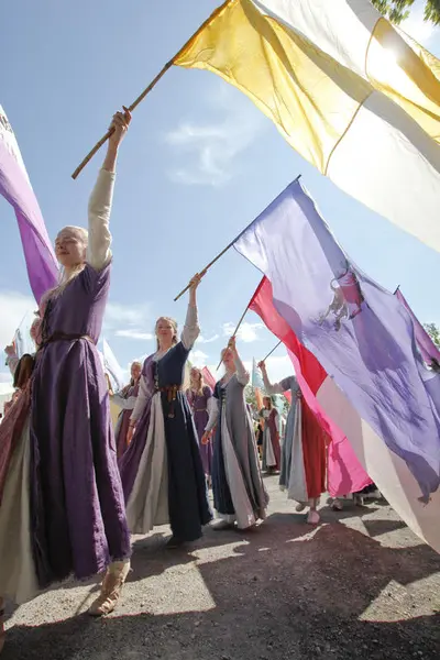 jenter i middelalderkjoler med fargerike flagg