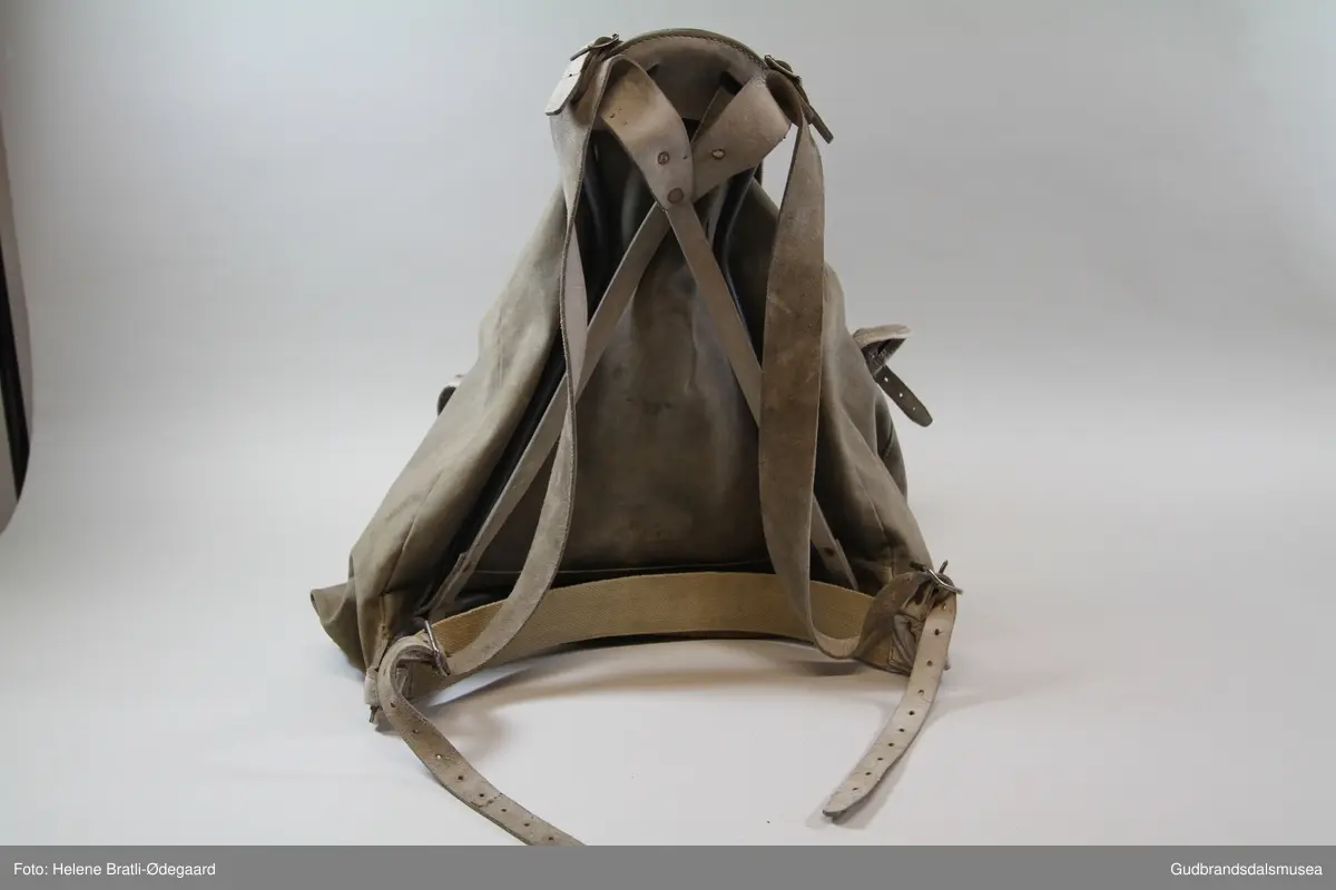 Ryggsekk antakelig fra fra 1930-tallet. Likhetstrekk med  Bergans Original Sverre Young og Peer Gynt sekker fra samme periode. Meis i metall. Bred lomme med lokk, lærreimer og metallspenner på front. To sidelommer. Lokkreimer av lær og metallspenner på lær sydd/nittet på sekken. Hoderom med snørelukning i malje og lokk med lærreimer og metallspenner. Ryggreimer i lær. Korsryggstøtte i kraftig stoff, boltet til meisendene. Lerretsforsterkning på sekk bak nedre meisrør. Alle lokk er kantet med lærforsterkninger. Lærholder rundt toppen av meisen med fester for ryggreimer.
