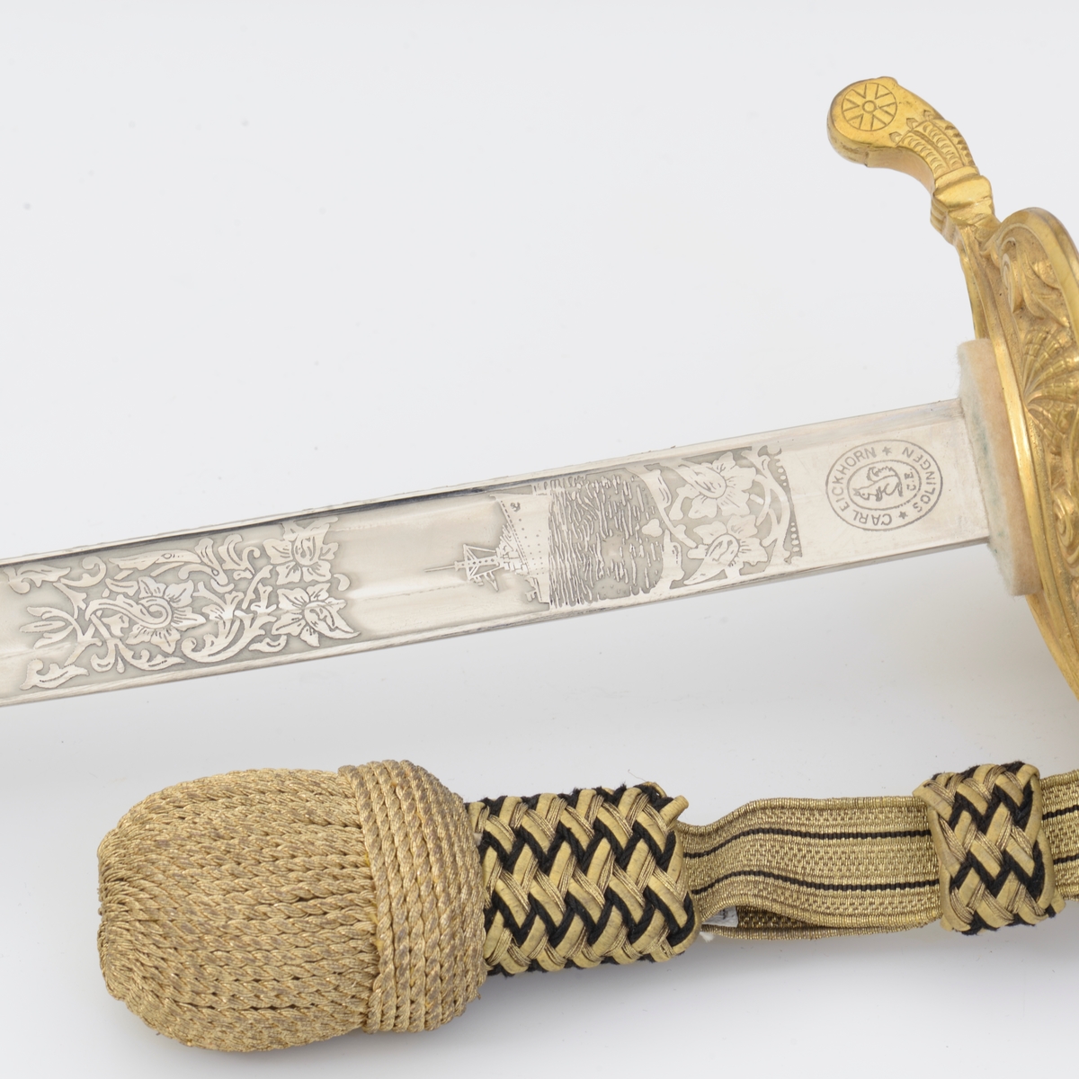 Norsk marinesabel Modell 1842. Feste i forgyllyt messing. Flat knapp med blomstermotiv. Nakkestykke merket "Lars Yggeseth"
Hvitt plastgrep med riller med snodd messingtråd i rillene. Gjennombrutt parerplate på utsiden med urent anker..Bakre parerstang svakt medbøyd og ender i en flattykt kule. Fremre parerstang går over i håndbøylen.
Gulltråde portepé flettet med alternativt svart/mørkeblått og gull.
Svakt krummet enegget klinge med rygg- og midtstillt blodrand. Klingen har etset dekor med moderne marinefartøy og kronet urent anker. Klimgen er merket med Carl Eichorns Solingenstempep i en oval rundt et ekorn.
Lærbalg med forgyllte messingbeslag. Munnblikket merket med norsk løve på forsiden og " Y " på baksiden. Midtbåndet er merket med kronet urent anker. Doppskoen har Neptuns tref ork og militære attributter.