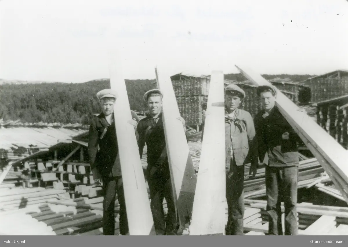 Motiv fra sagbruket på Jakobsnes før 1940. Plankebærere, materialstabler i bakgrunnen.