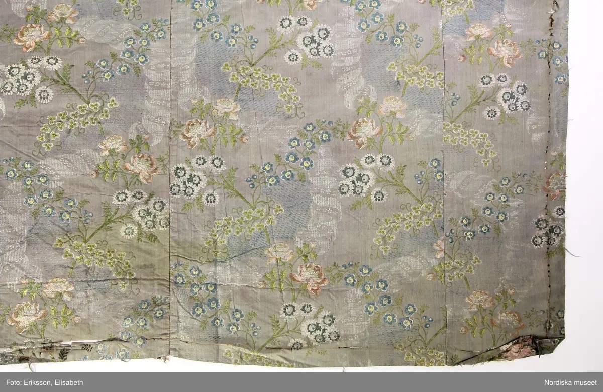 En välbevarad rokokobrokad från 1700-talets mitt som innan det syddes samman till det nuvarande stycket sannolikt tjänat som robe. Textilen är ett bra exempel på hur dyra tyger återbrukades.

/Ulla-Karin Warberg 2017-08-01