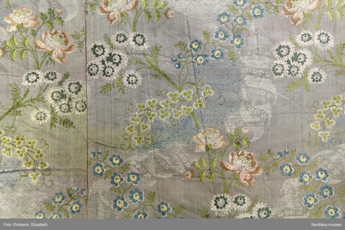 En välbevarad rokokobrokad från 1700-talets mitt som innan det syddes samman till det nuvarande stycket sannolikt tjänat som robe. Textilen är ett bra exempel på hur dyra tyger återbrukades.

/Ulla-Karin Warberg 2017-08-01