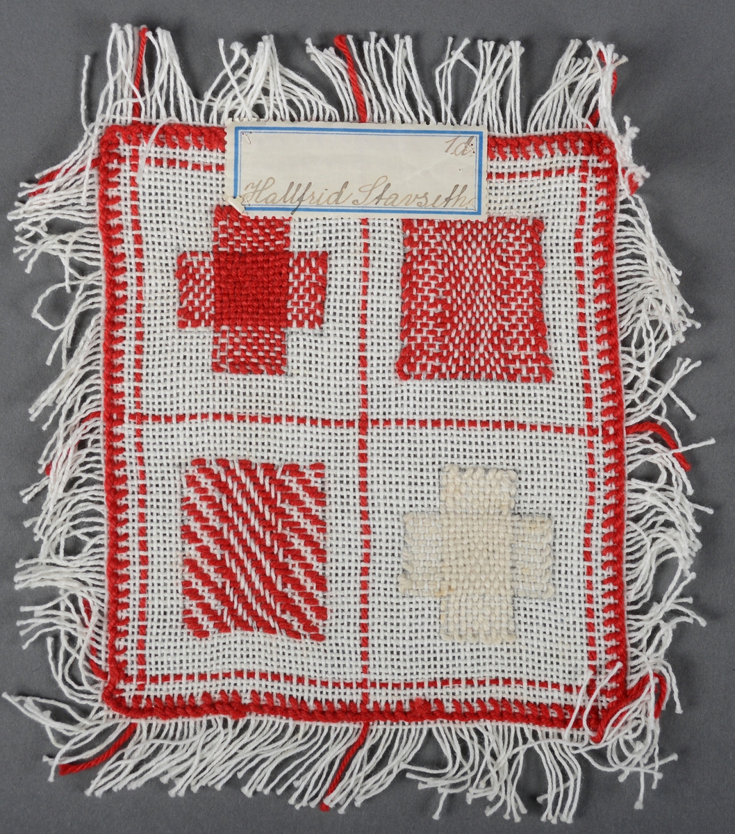 Prøvelapp med 4 stoppeteknikker. Prøvelappen er kantet opp for hånd og har frynser. Påsydd merkelapp med tekst.