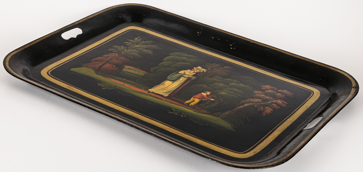 Bricka av svartlackerad plåt, målad med figurer i landskap,fyrkantig 1820-tal.
Fyrsidig med rundade hörn. Handtag urtagna i kortsidornas bräm. Svart bild i grönt, gult, rött mm. Inom guldram: kvinna och pojke mot bakgrund av träd mm. Dräkterna tidigt 1800-tal.