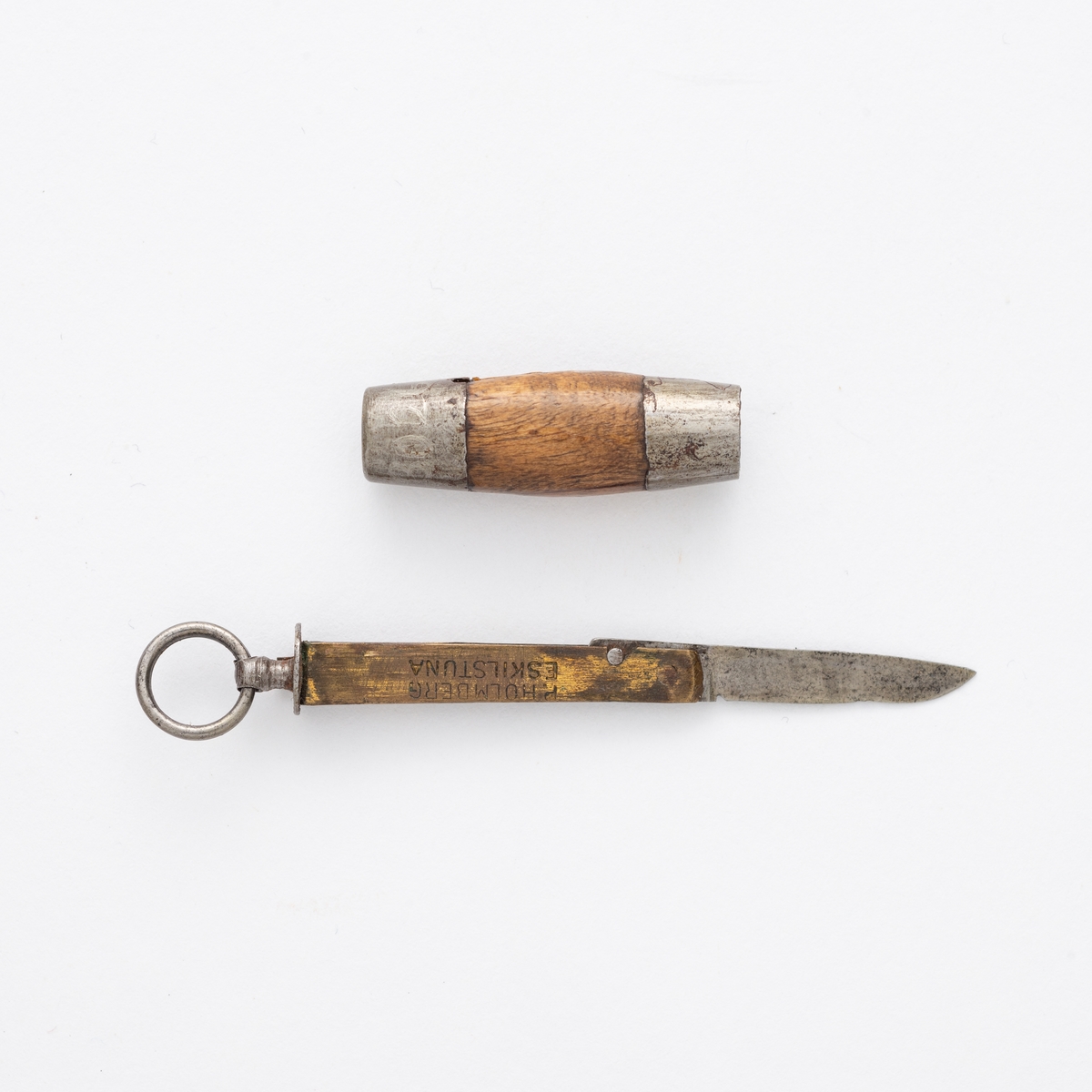 Liten sammenleggbar kniv i stål og messing med oval slire i tre og metall. Metallring til å trekke kniven ut av sliren.