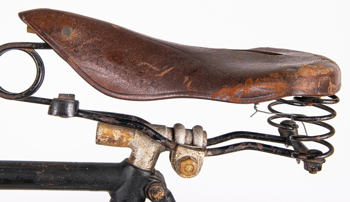 Cykel från 1800-talets slut.
Svartmålad. Gummidäck. Pakethållare i fram. Brun sadel av läder.
Den är tysk och är av märket Brennabor, modell No 1. Firman låg i Brandenburg.
Den är från sista årtiondena på 1800-talet.
Registreringsskyl i glas, nummer 5198.