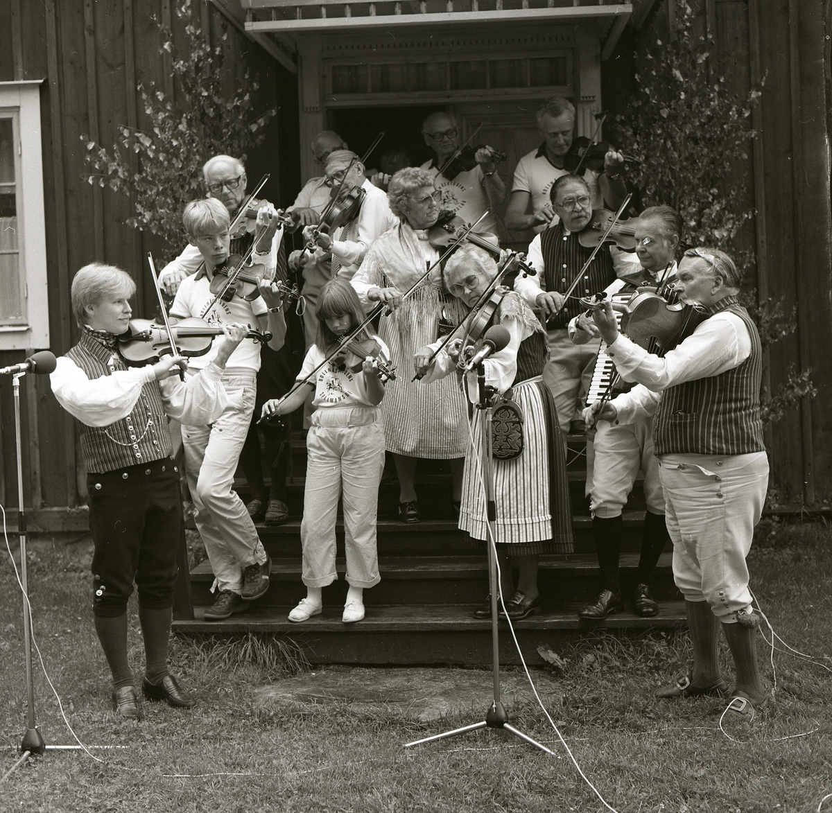 Fiolspelare och en dragspelare upptäcker vid Förenigsbankens medaljering vid Rengsjöfesten 15 juli 1984.