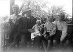 Ruben Liljefors med barnen Roland, Alf, Ingemar och Marit, sitter ute på verandan, sannolikt i Sverige