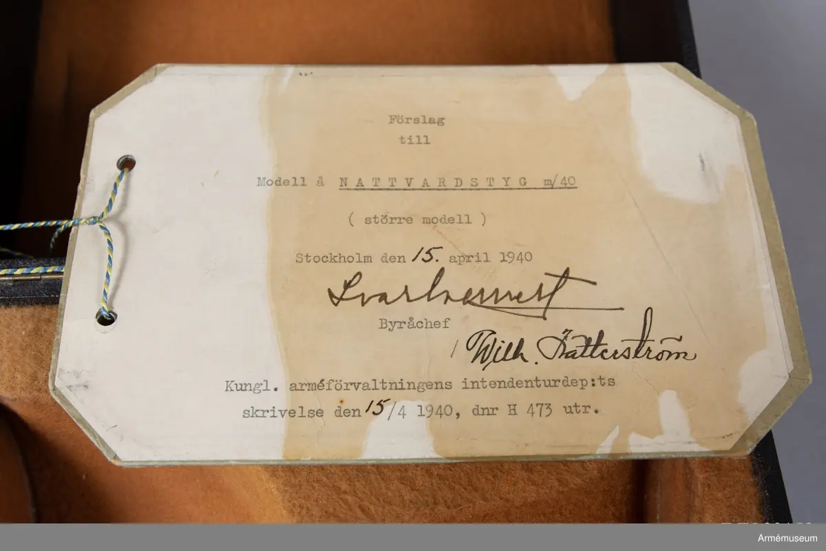 Modellexemplar av nattvardskalk m/1940, större modell i tenn. Märkt "N Redeby" inuti foten. Förvaras tillsammmans med paten i svart fodral försett med sigill samt etikett signerad av byråchefen för Kungliga arméförvaltningens intendenturdepartement den 15 april 1940.
