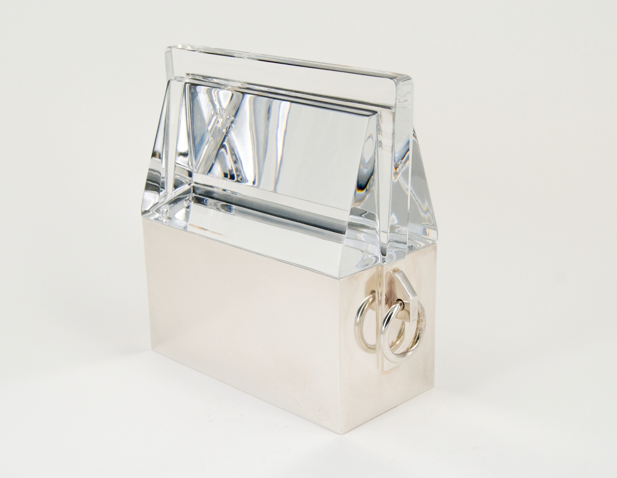 Skulptur, "Uppsala" av Gunna Cyrén. Av silver och glas. Föreställande, schematiskt, S:t Eriks relikskrin i Uppsala domkyrka. 
Slät dekorerad underdel i silver samt tak (löst), av massivt glas. Öglor i underdelens kortsidor.

Mindre skada i glaspartiets ena kortsida nertill.